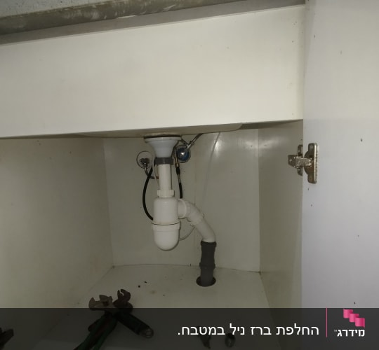 כלים וצנרת מתחת לכיור במטבח